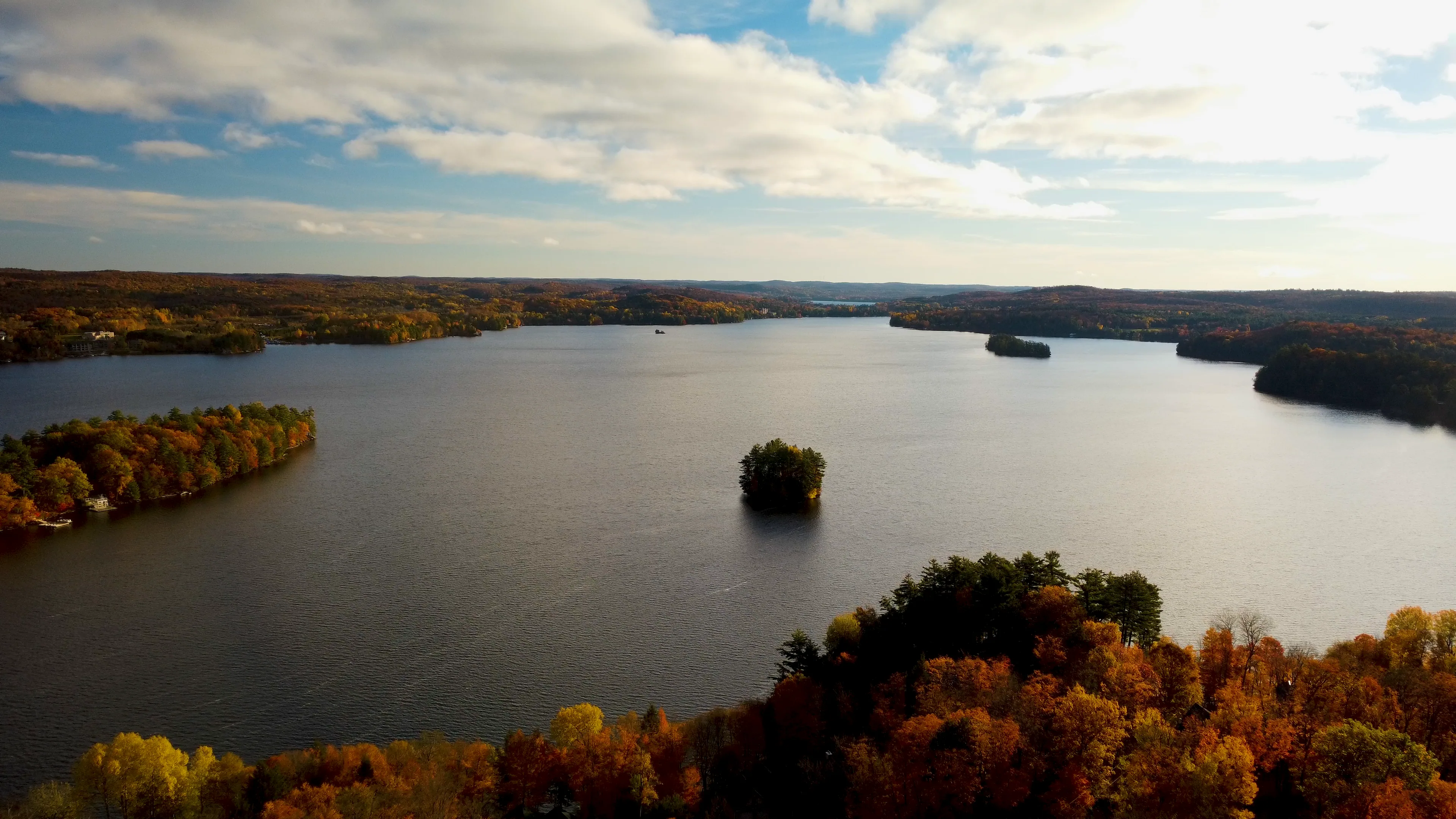 Aerial view of a lake and autumn shoreline.
